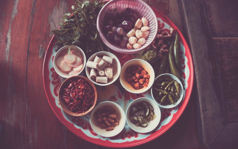 Assorted dried Thai medicinal herbs in linen pouches for home wellness tea and steam therapy